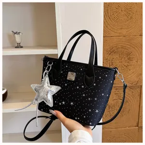 Vista dettagliata della borsa nera con stampa di stelle e ciondolo a stella argento lucido.