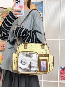 Detailed shot of cute polka dot canvas ita-bag featuring clear display window and brown PU trim.