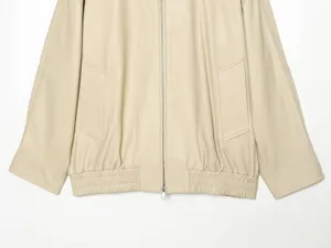 Detailopname van beige kunstlederen damesjack met ritssluiting en praktische zakken.