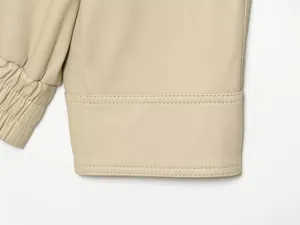 Dames imitatielederen jas mouw detail close-up, beige PU motorfiets bovenkleding.