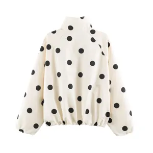 Detailed view of women fashion polka dot print bomber jacket in cream and black color.