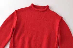 Detailansicht des roten Strickpullovers mit Stehkragen, weiche Textur und Kragendetails.