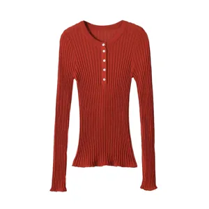 Ribbed knit fabric detail showing fine vertical texture and neat button placket on long sleeve top.