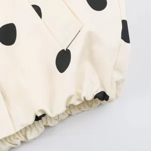 Close-up detail of women fashion polka dot jacket showing textured fabric and elastic hem.