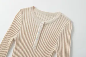 Beige round neck long sleeve knit top with decorative button front and fine ribbed texture.