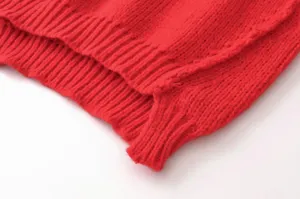 Detailaufnahme eines roten asymmetrischen Strickcardigans mit feiner Rippenstruktur.