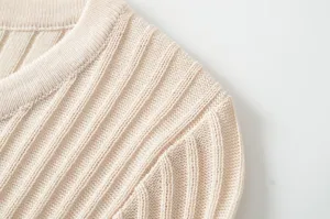 Ribbed knit sweater detail, close-up shot of beige crew neck and shoulder texture.