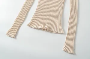 Women's elegant beige ribbed knit long sleeve slim fit top with stylish ruffled hem.