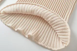 Close-up detail of women ribbed knit sweater hem, soft fabric texture, apricot color.