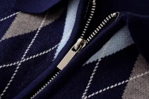 Detalle de jersey de punto con patrón Argyle, cremallera metálica y textura suave.