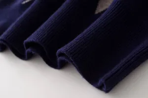 Primer plano de la tela del suéter de punto azul marino con puños acanalados.