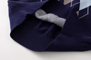 Primer plano de los detalles del jersey de punto argyle azul marino, tejido suave y dobladillo.