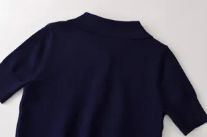 Detalle de top de punto azul marino, cuello clásico, manga corta, estilo diario.