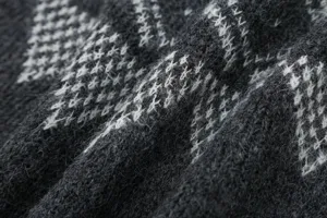 Primo piano dettagliato della texture del tessuto in maglia jacquard grigio.