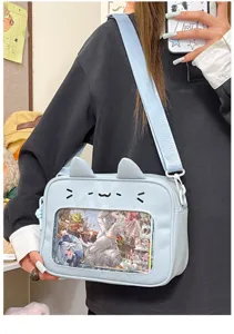 Detail view of cute light blue ita bag featuring cat ears design and clear window display.
