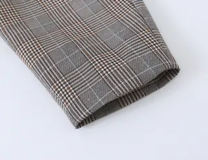 Detail view of women casual plaid suit jacket fabric, classic houndstooth cuff texture.