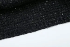 Close-up view of black metallic glitter knit sweater fabric texture and fine details