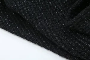 Black sparkle knit fabric detail close up view, elegant shimmering texture sweater material.