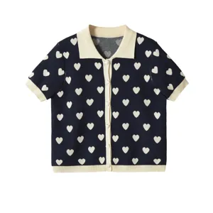 Vue rapprochée du cardigan en tricot jacquard cœur avec col et boutons contrastés.
