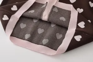 Gros plan detail de cardigan en tricot marron pour femme motif jacquard coeurs.