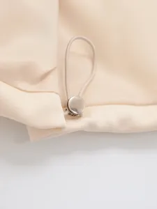 Close-up detail of women's casual garment drawstring with metallic cord stopper and soft fabric.