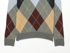 Primer plano de los detalles del jersey de punto argyle para mujer con clásico patrón romboidal.