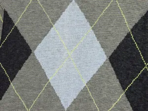 Primer plano detallado del tejido de suéter de punto argyle con textura de rombos.