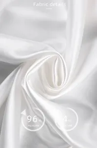 Gros plan de détail en tissu satin de soie blanc avec texture lisse et composition polyester.