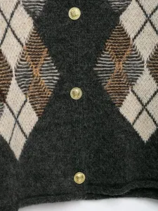 Detaillierte Aufnahme eines klassischen Argyle-Strickcardigans mit goldenen Knöpfen.