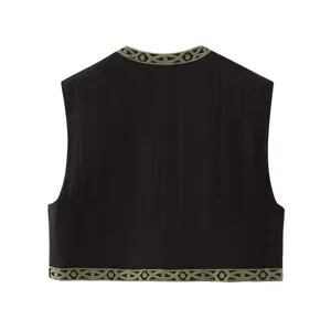 Vista detallada del chaleco negro bordado con cuello redondo y elegantes patrones verdes.