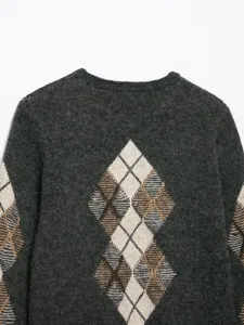 Detailansicht eines dunkelgrauen Strickpullovers mit klassischem Rautenmuster am Rücken.