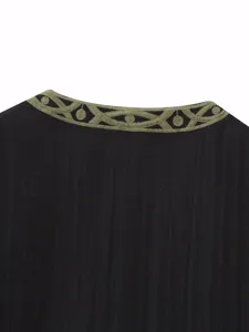 Vista detallada chaleco negro de mujer con cuello redondo bordado verde oliva estilo casual diario.