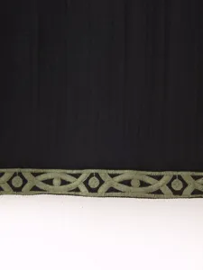 Primer plano del dobladillo de la prenda con elegante bordado geométrico verde oliva.