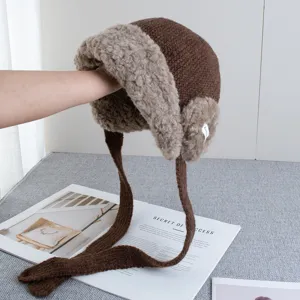 Winter warm brown knitted trapper hat with fluffy faux fur lining and ear flaps.