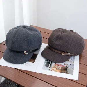 Gros plan détaillé de la casquette rétro en laine avec boucle métallique sur table.