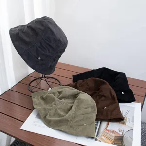 Close-up view of retro pleated suede bucket hats in various colors with delicate metal detail.