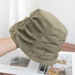 Detailed view of a vintage retro pleated suede bucket hat in olive green, stylish casual cap.