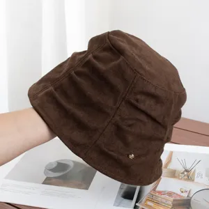 Close-up detail of retro brown suede bucket hat featuring pleated design and metal accent.