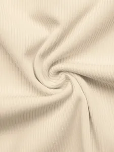 Primo piano dei dettagli del tessuto a costine beige con consistenza morbida e righe verticali.
