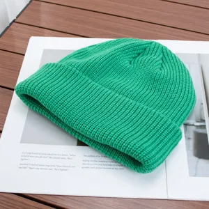 Green knit beanie detail showing fine wool texture and warm cuff design for winter wear