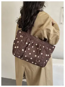 Vista dettagliata della borsa tote marrone a pois con doppi manici e pratiche tasche laterali.