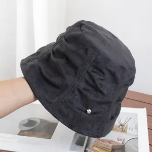 Close-up of dark grey faux suede bucket hat, showing soft pleating texture and autumn style.