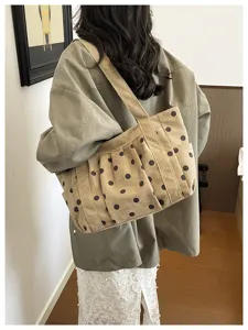 Dettaglio della borsa a tracolla in tela stile coreano con pois marroni e pieghe.