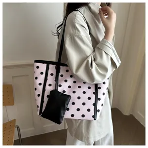 Borsa tote alla moda a pois rosa con spallacci neri e piccola pochette coordinata da donna.