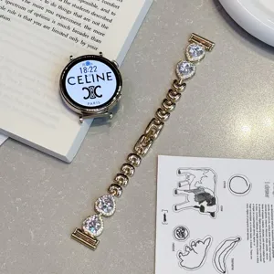 Detail de bracelet montre connectée en métal doré avec cristaux zircone sur table grise.