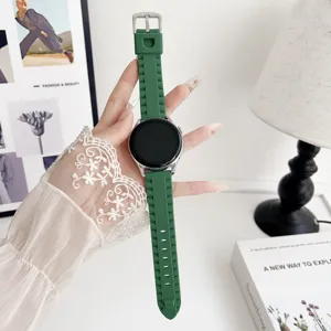Vue de detail rapprochee du bracelet de montre en silicone vert avec motif pneu.