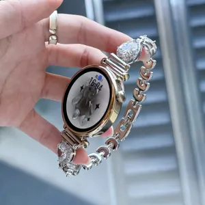 Vue détaillée du bracelet de montre en métal avec cœurs en zircone scintillants et maillons.