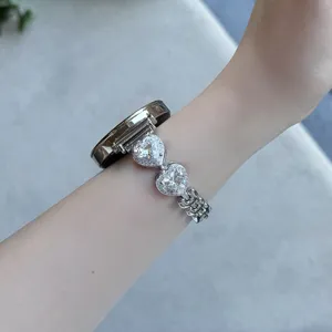 Bracelet de montre connectée en métal avec cristaux cœur étincelants, détail élégant poignet.
