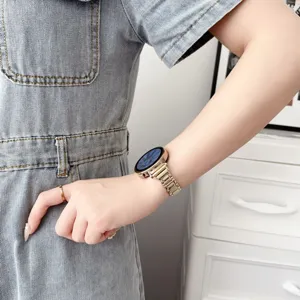 Bracelet de montre en métal fin doré, porté au poignet pour un style élégant et moderne.