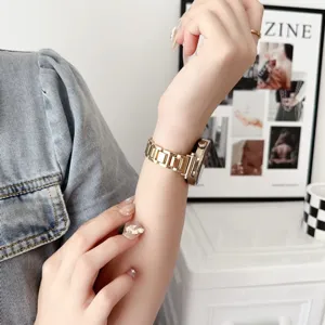 Gros plan détaillé d'un élégant bracelet de montre en métal doré sur un poignet fin.
